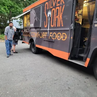 a man standing next to a food truck