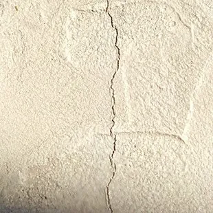 One of 30+ cracks on deck, some extending from outer edge of deck across the deck and around the edge toward the tile and water.