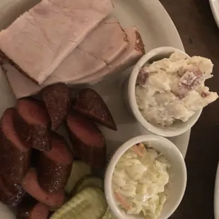 Meats of two hot sausage links turkey potato salad and coleslaw