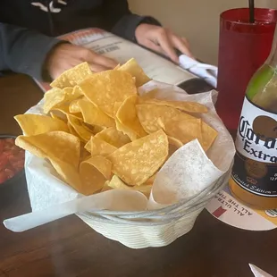 a basket of chips and a bottle of beer