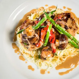 a plate of pasta with mushrooms and asparagus