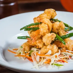a white plate with a pile of fried food on it