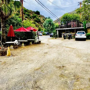a parking lot with tables and umbrellas