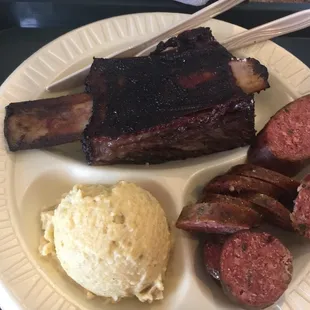 Impressively large beef rib, lots of sausage, and a good scoop of potato salad.