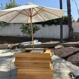 Tables, umbrellas, natural wood chairs.