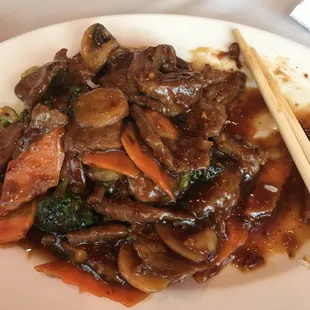 a plate of stir fried beef and vegetables