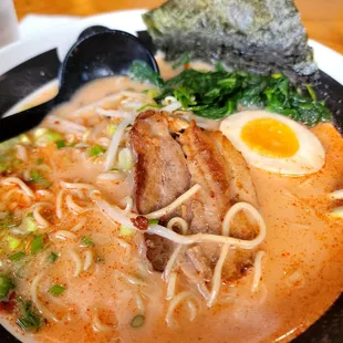 a bowl of ramen with an egg and a roll