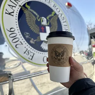 a hand holding a coffee cup