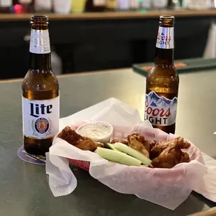 two beer bottles and a basket of food