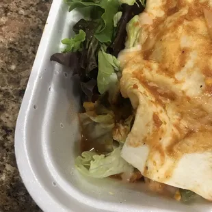 a closeup of a meal in a styrofoam container