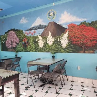 a dining room with a mural on the wall