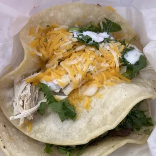 shredded chicken and cheese on a tortilla