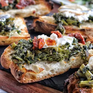 a close up of a piece of bread with spinach and cheese