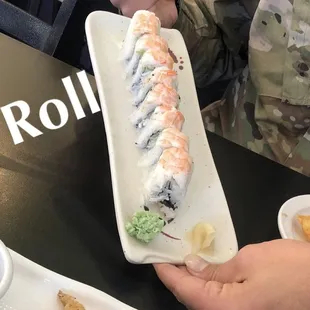 a person holding a plate of sushi