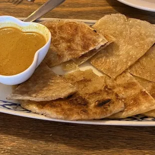a plate of pita chips and a bowl of dipping sauce