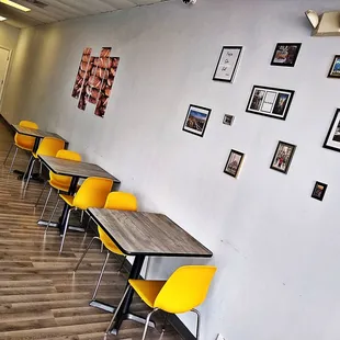 a row of tables and yellow chairs