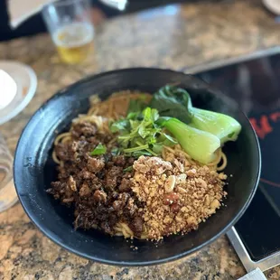 a bowl of noodles with meat and vegetables
