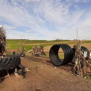 a tractor and a pile of tires on a dirt road