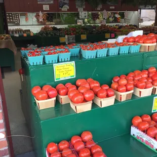a display of tomatoes in baskets