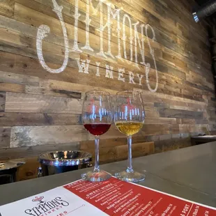 two glasses of wine on a bar