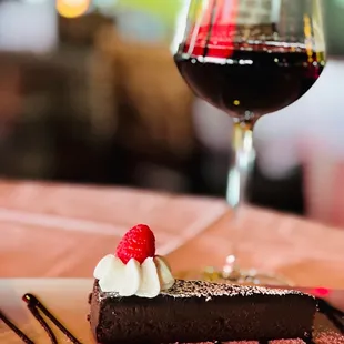 a piece of chocolate cake and a glass of wine