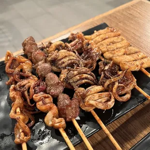 skewered meat on a black plate