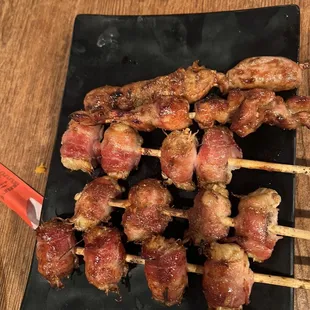 bacon skewers on a black plate
