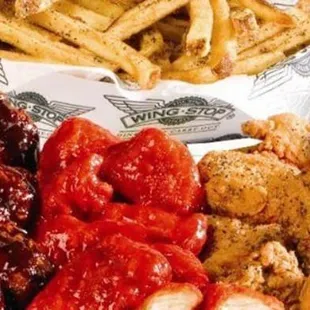 a plate of chicken wings, fries, and ketchup