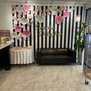 a black and white striped wall with paper flowers