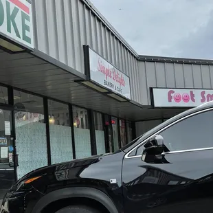 a black car parked in front of a store