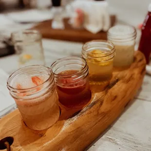 a row of jars of sauces on a wooden tray