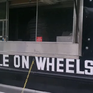 a black food truck with a menu on the side
