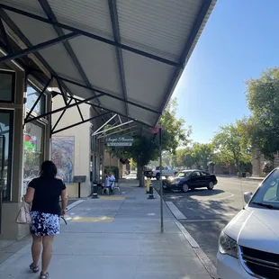 a woman walking down the sidewalk