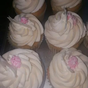cupcakes with white frosting and pink decorations
