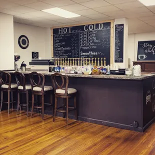 a coffee shop with a chalkboard menu on the wall