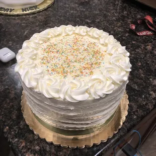 a cake with white frosting and sprinkles