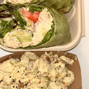 a sandwich and a salad in a styrofoam container