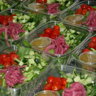 a variety of salads in plastic containers