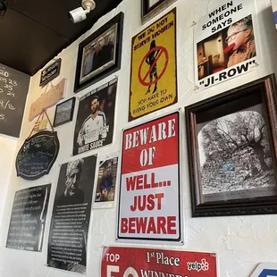 a wall full of signs and posters