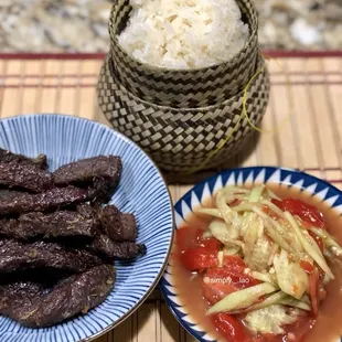 Lemongrass Beef Jerky with spicy cucumber salad and sticky rice.