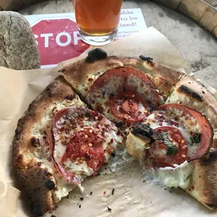 a half eaten pizza and a glass of beer