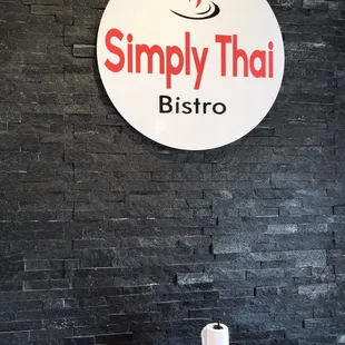 a table and chairs in front of a brick wall