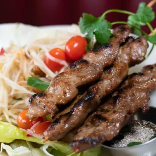 Moo Ping-SomTum - Marinated pork on skewers served with traditional spicy tamarind sauce, sticky rice and Papaya salad