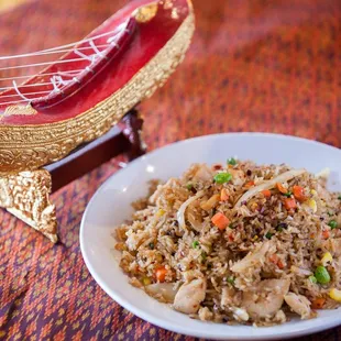 a plate of fried rice with chicken and vegetables