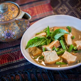 a bowl of soup and a teapot