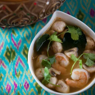 a bowl of soup with shrimp and vegetables