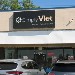 two cars parked in front of a store