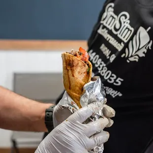 a person holding a sandwich