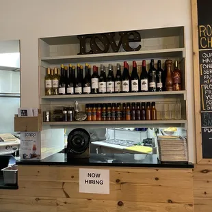 a counter with a sign that says now hiring