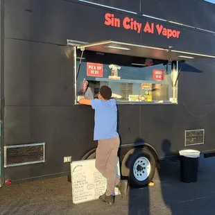 a man standing at a food truck